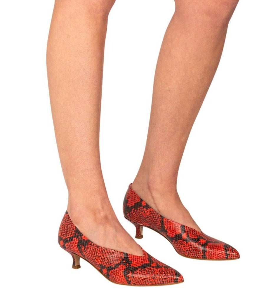 Italian leather red snakeskin kitten heel pumps with pointed toe and deep V cut on model