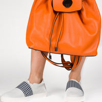 orange leather drawstring top backpack white slip on sneakers